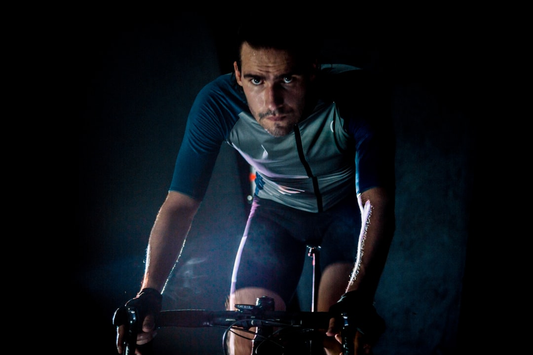 Close-up of a cyclist pedaling on a road bike with a power meter visible.
