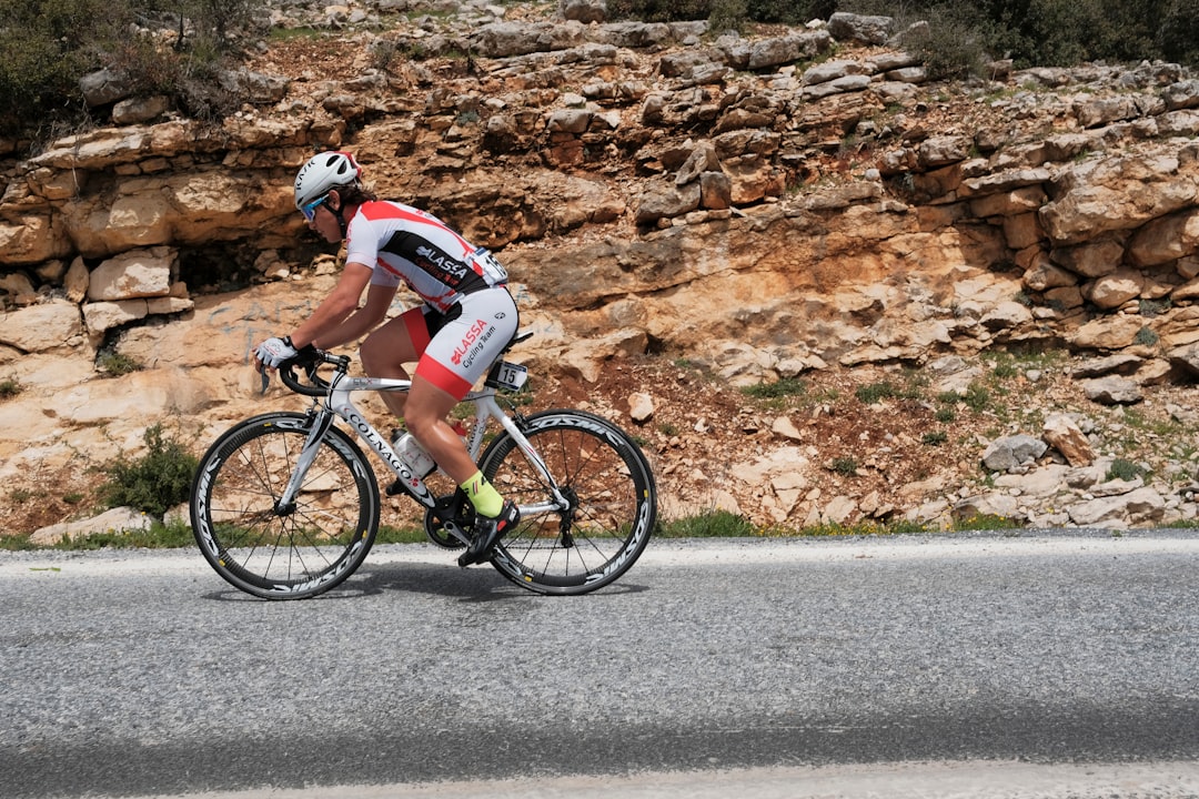 Close-up of a cyclist pedaling on a road bike with a power meter visible.