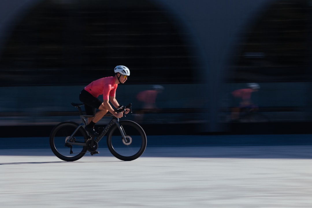 Close-up of a cyclist pedaling on a road bike with a power meter visible.
