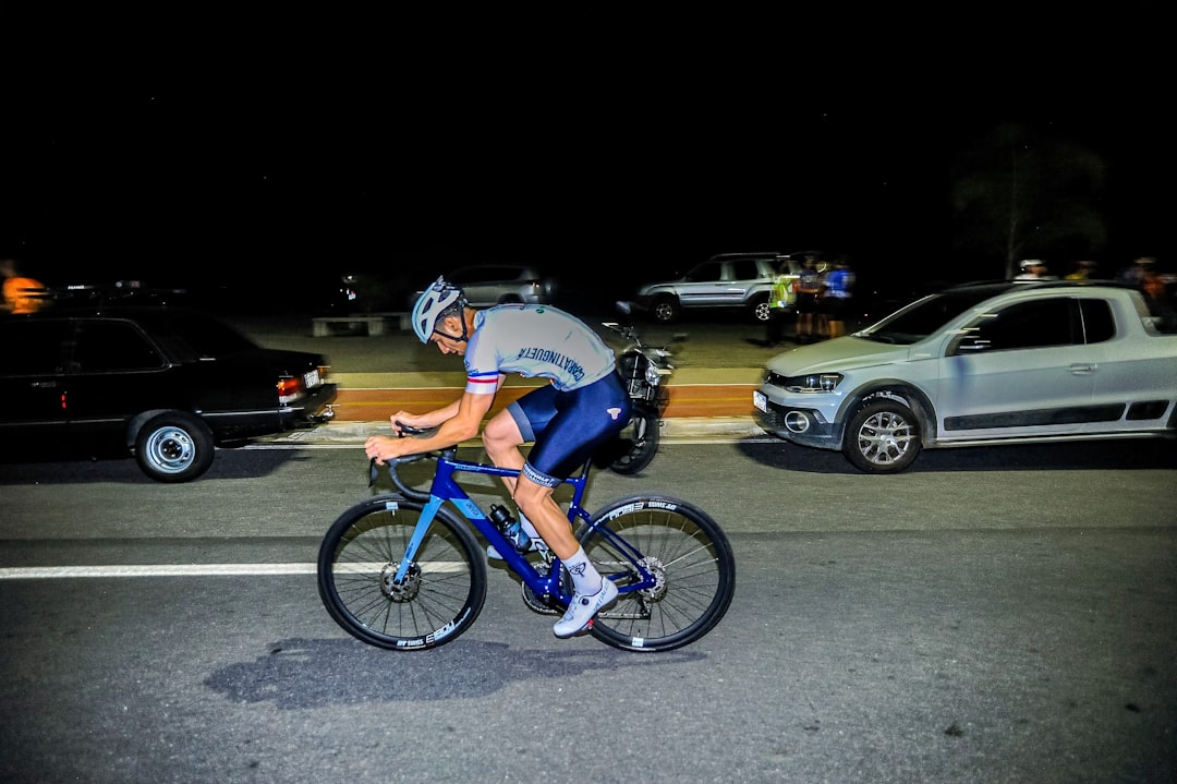 Close-up of a cyclist pedaling on a road bike with a power meter visible.