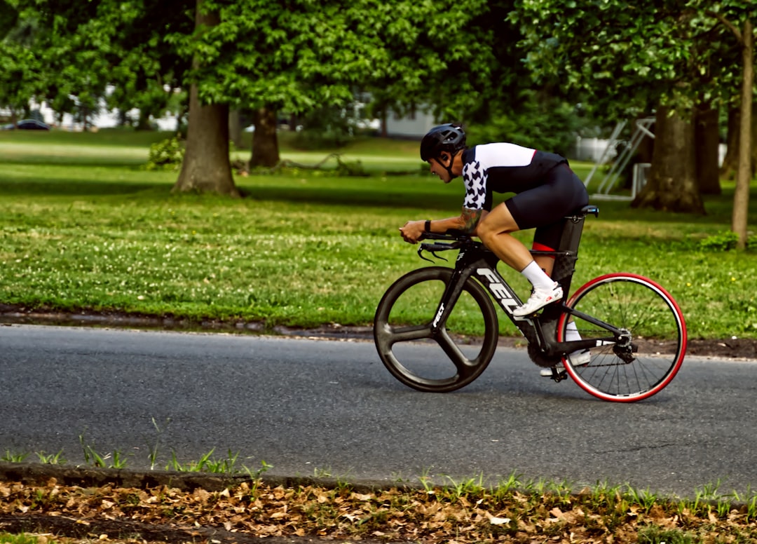 Close-up of a cyclist pedaling on a road bike with a power meter visible.