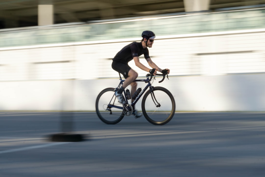 Close-up of a cyclist pedaling on a road bike with a power meter visible.