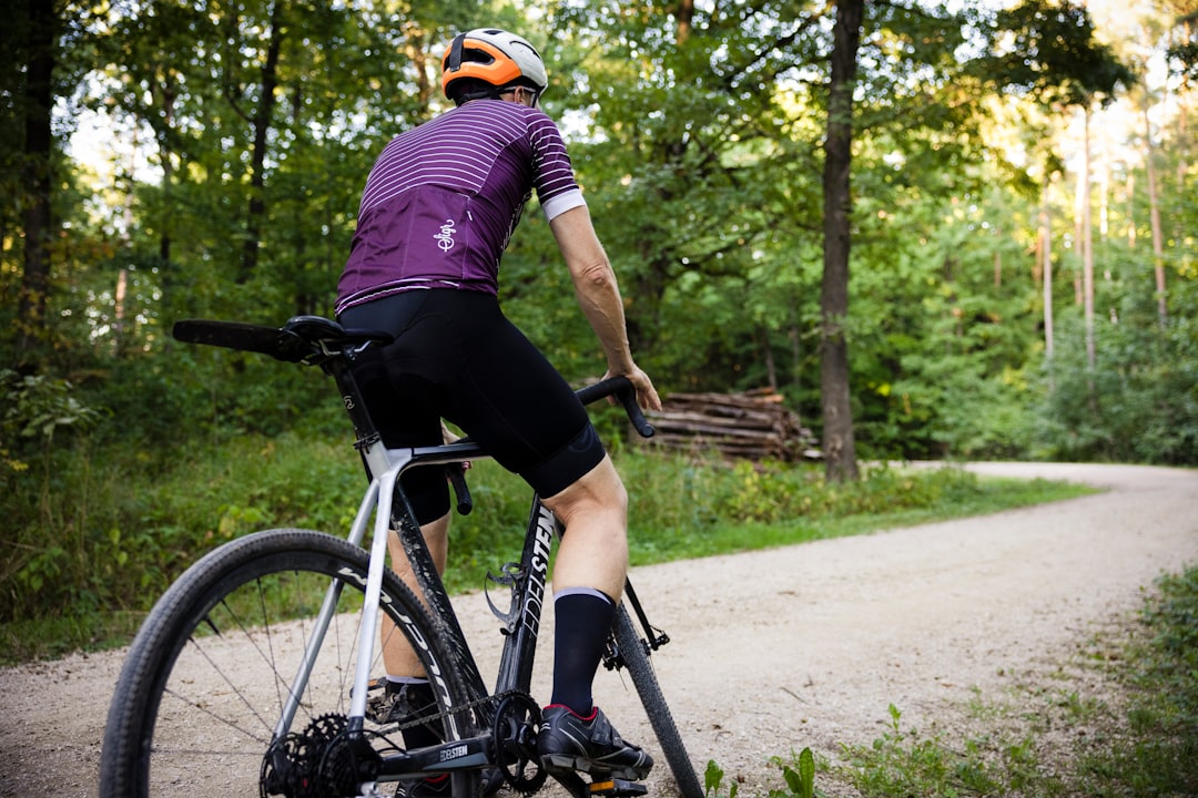 Close-up of a cyclist pedaling on a road bike with a power meter visible.