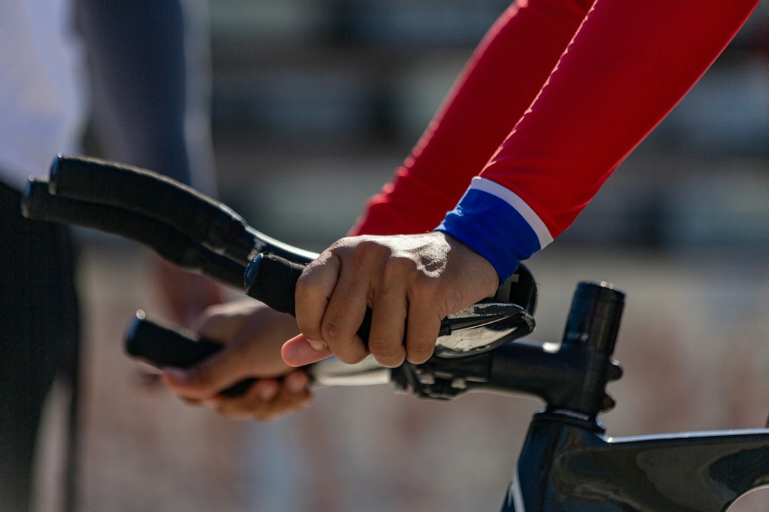 Close-up of a cyclist pedaling on a road bike with a power meter visible.