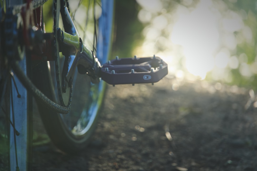 Close-up of a cyclist pedaling on a road bike with a power meter visible.