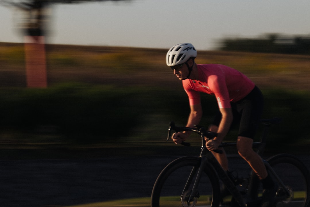 Close-up of a cyclist pedaling on a road bike with a power meter visible.