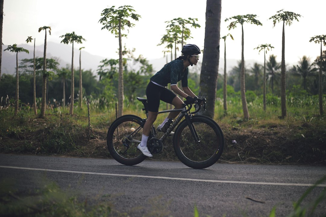 Close-up of a cyclist pedaling on a road bike with a power meter visible.
