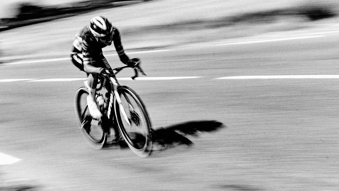 Close-up of a cyclist pedaling on a road bike with a power meter visible.