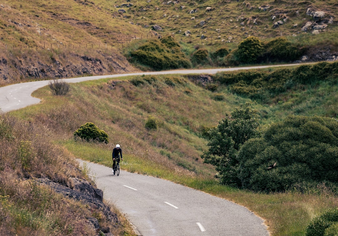 Close-up of a cyclist pedaling on a road bike with a power meter visible.