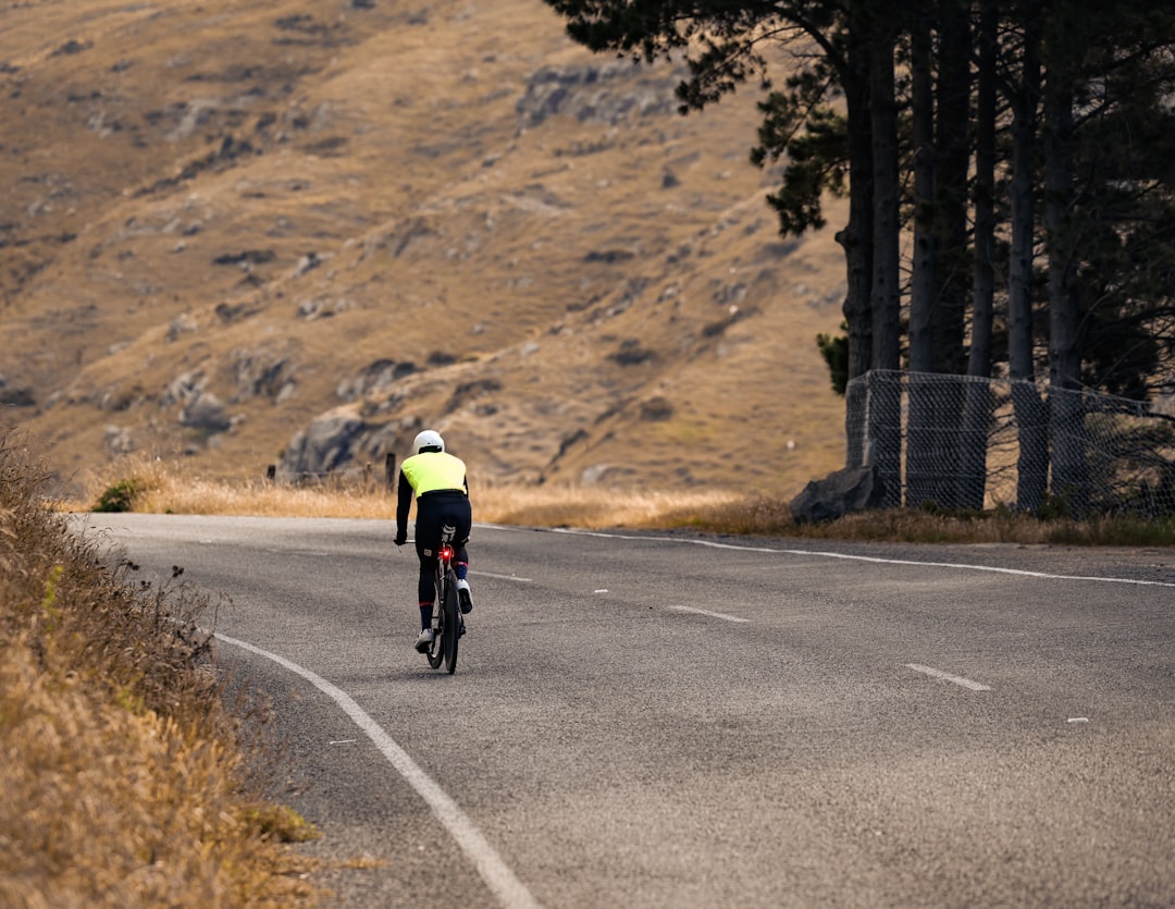 Close-up of a cyclist pedaling on a road bike with a power meter visible.