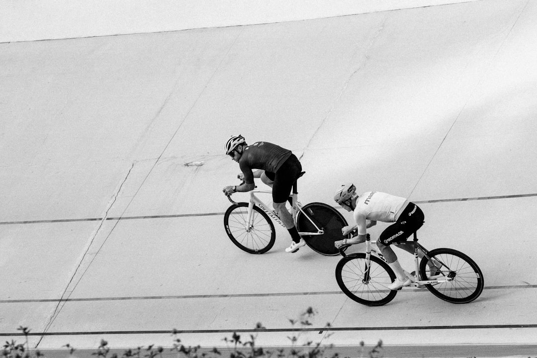 Close-up of a cyclist pedaling on a road bike with a power meter visible.
