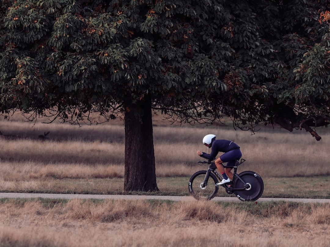 Close-up of a cyclist pedaling on a road bike with a power meter visible.