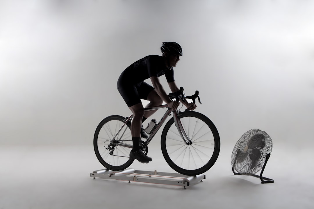 Close-up of a cyclist pedaling on a road bike with a power meter visible.