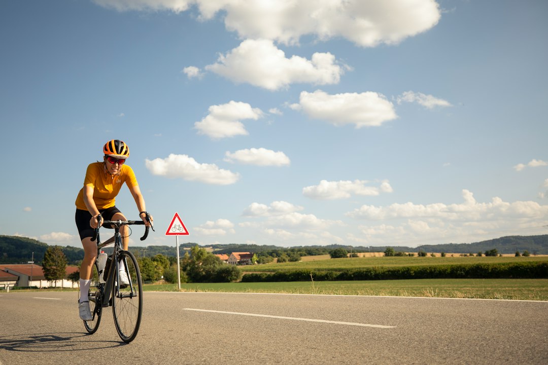 Close-up of a cyclist pedaling on a road bike with a power meter visible.