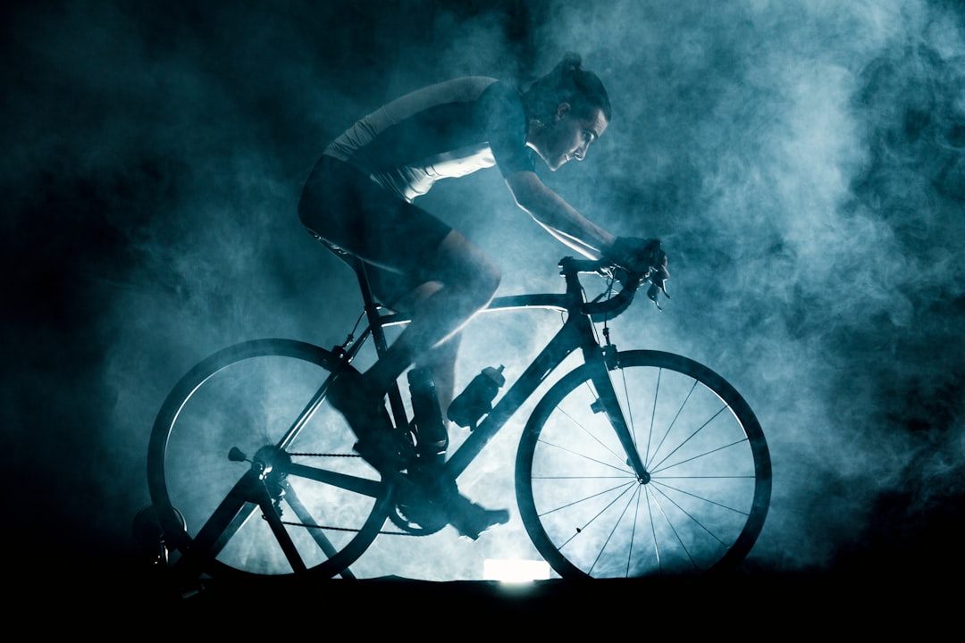 Close-up of a cyclist pedaling on a road bike with a power meter visible.