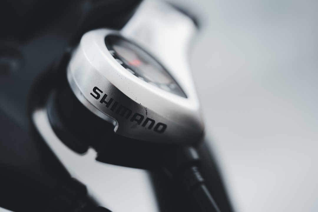 Close-up of a cyclist pedaling on a road bike with a power meter visible.