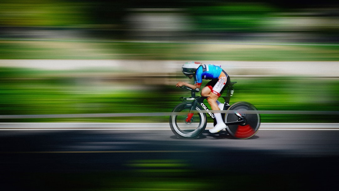 Close-up of a cyclist pedaling on a road bike with a power meter visible.