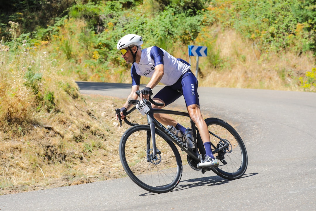 Close-up of a cyclist pedaling on a road bike with a power meter visible.