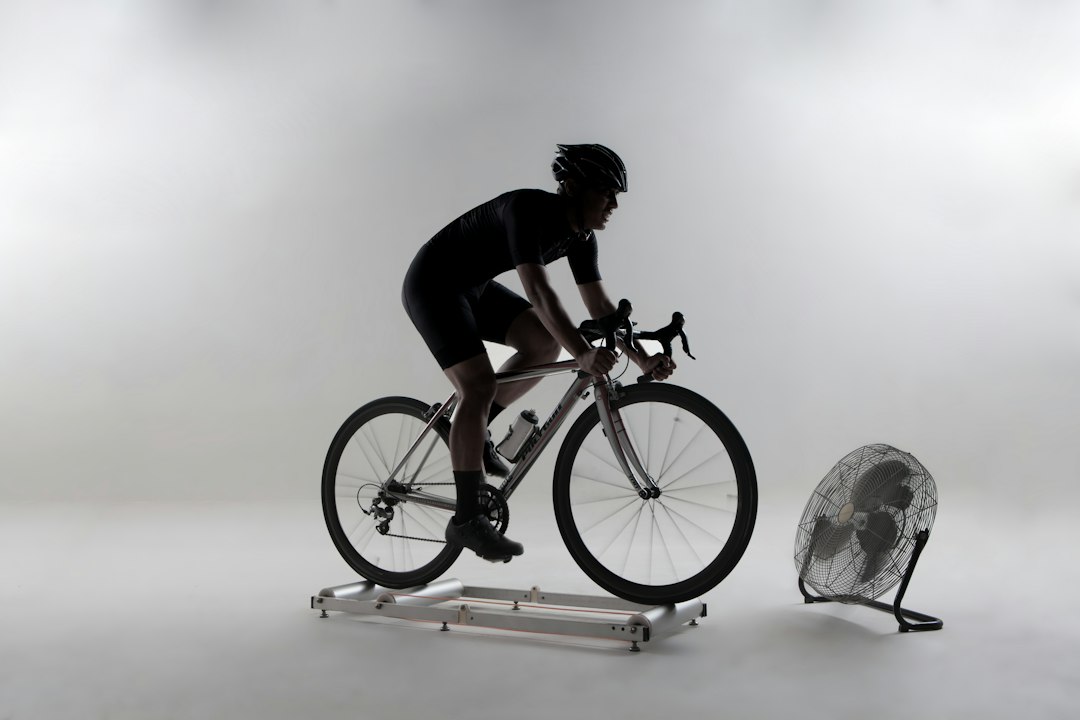 Close-up of a cyclist pedaling on a road bike with a power meter visible.