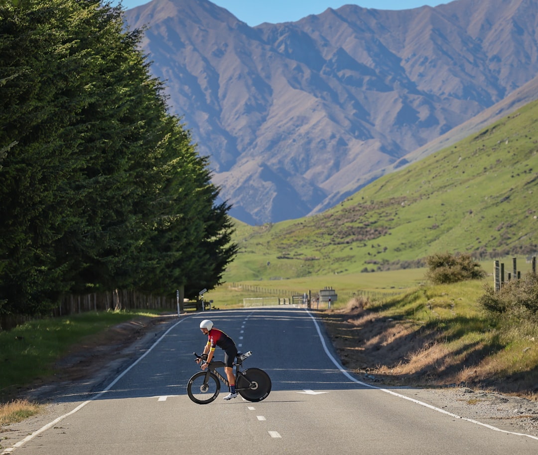 Close-up of a cyclist pedaling on a road bike with a power meter visible.