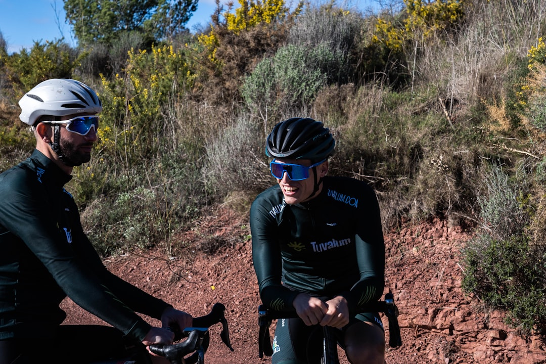 Close-up of a cyclist pedaling on a road bike with a power meter visible.