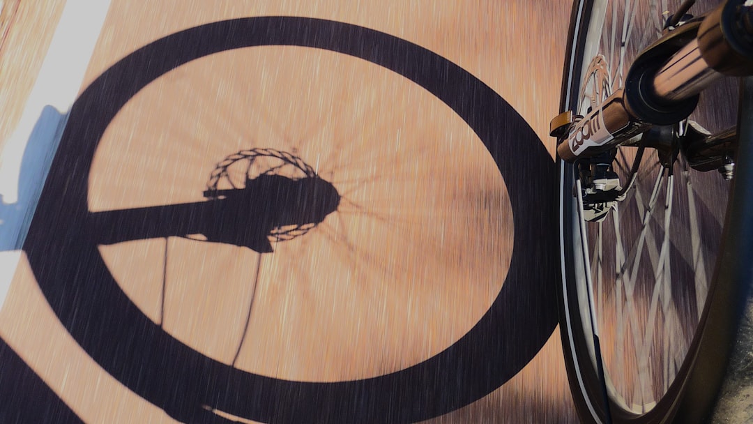 Close-up of a cyclist pedaling on a road bike with a power meter visible.