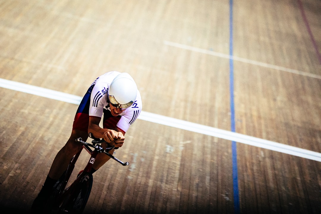 Close-up of a cyclist pedaling on a road bike with a power meter visible.