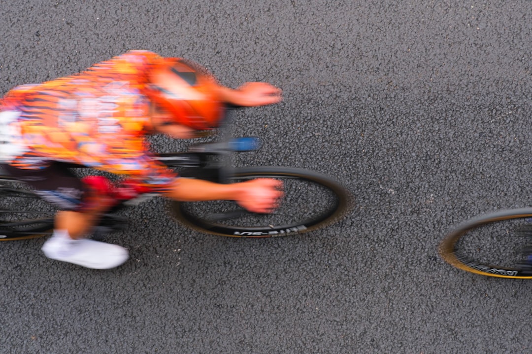 Close-up of a cyclist pedaling on a road bike with a power meter visible.