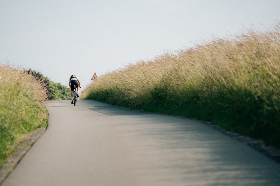 Close-up of a cyclist pedaling on a road bike with a power meter visible.