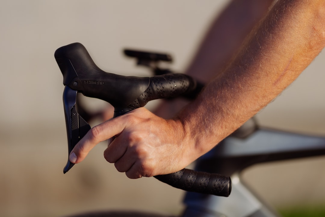 Close-up of a cyclist pedaling on a road bike with a power meter visible.