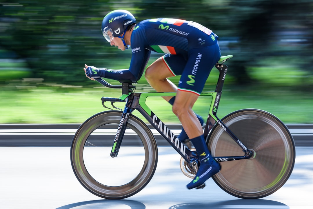 Close-up of a cyclist pedaling on a road bike with a power meter visible.