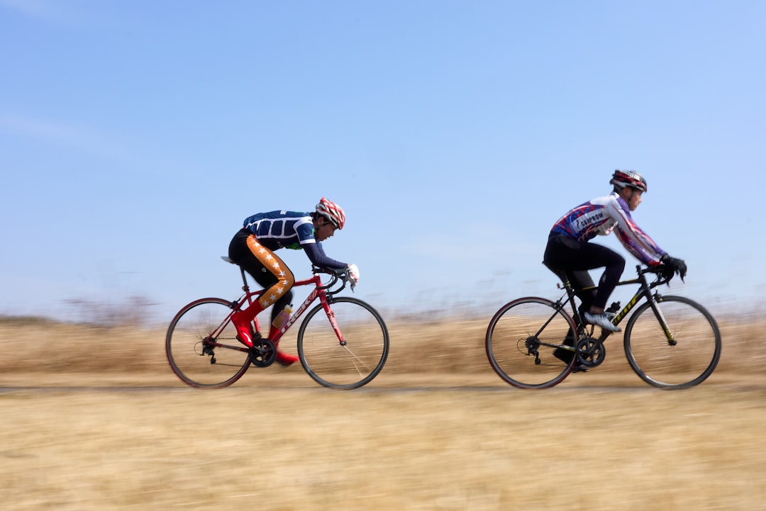 Close-up of a cyclist pedaling on a road bike with a power meter visible.