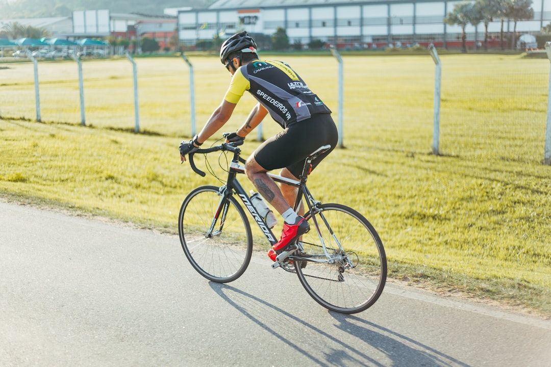 Close-up of a cyclist pedaling on a road bike with a power meter visible.