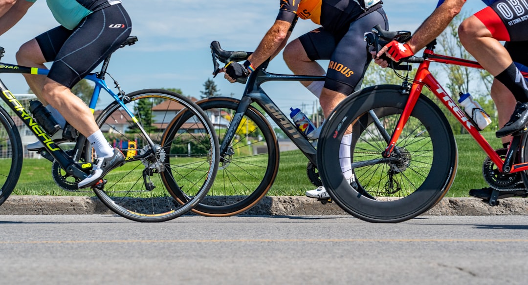 Close-up of a cyclist pedaling on a road bike with a power meter visible.