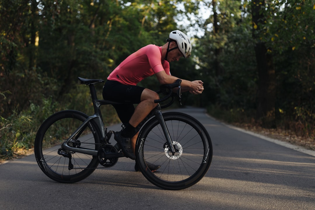 Close-up of a cyclist pedaling on a road bike with a power meter visible.