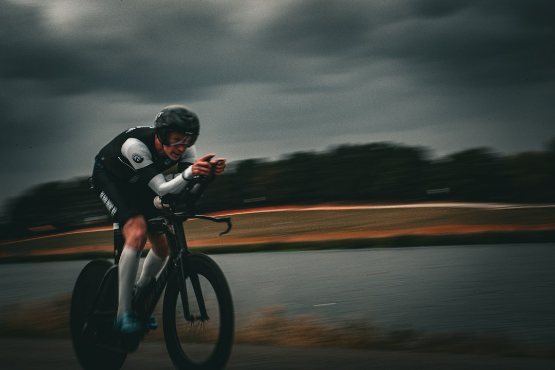 Close-up of a cyclist pedaling on a road bike with a power meter visible.