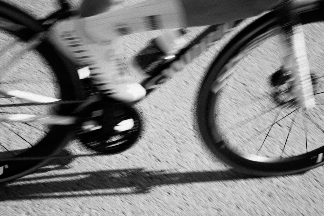 Close-up of a cyclist pedaling on a road bike with a power meter visible.