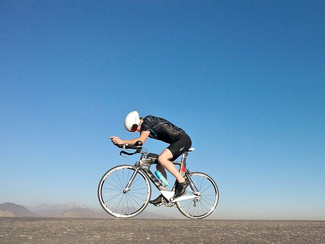 Close-up of a cyclist pedaling on a road bike with a power meter visible.