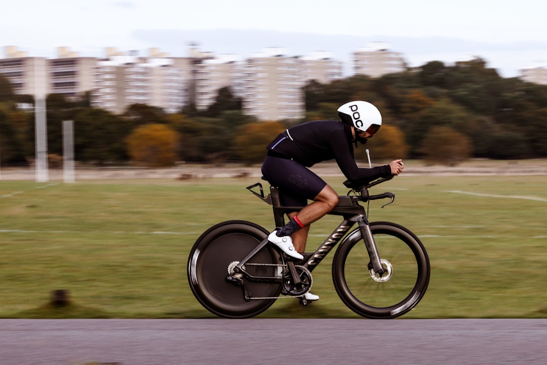 Close-up of a cyclist pedaling on a road bike with a power meter visible.