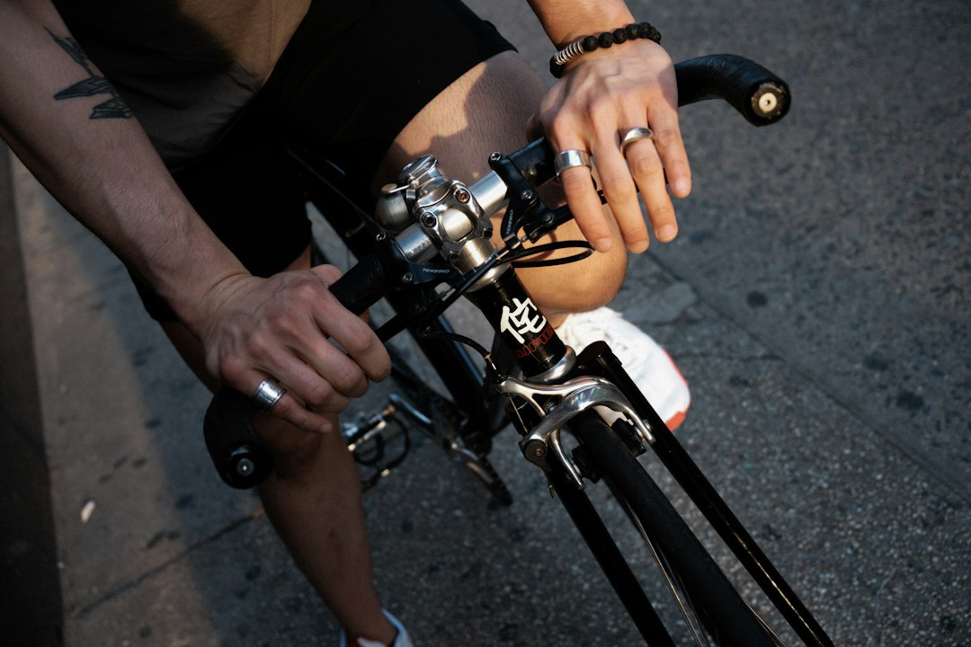 Close-up of a cyclist pedaling on a road bike with a power meter visible.
