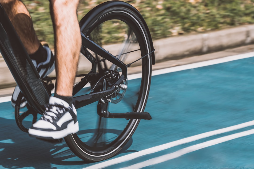 Close-up of a cyclist pedaling on a road bike with a power meter visible.