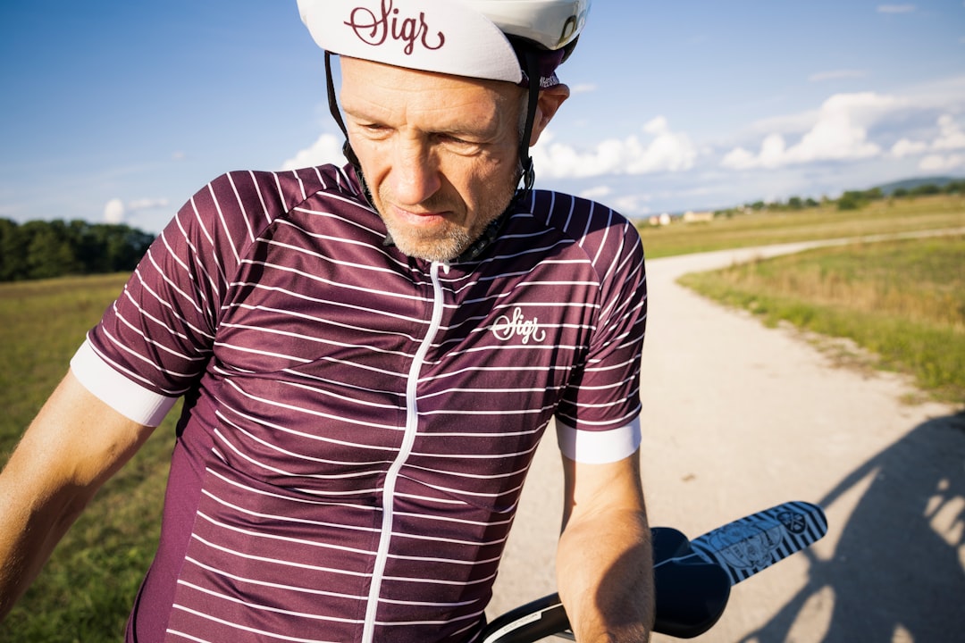 Close-up of a cyclist pedaling on a road bike with a power meter visible.