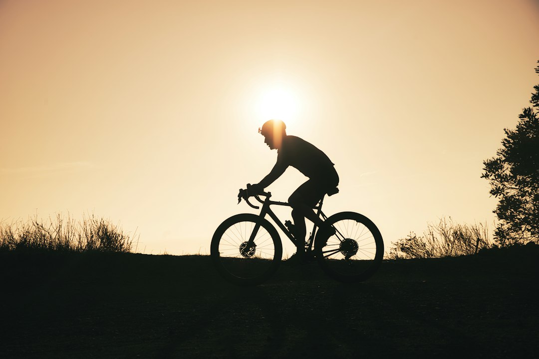 Close-up of a cyclist pedaling on a road bike with a power meter visible.
