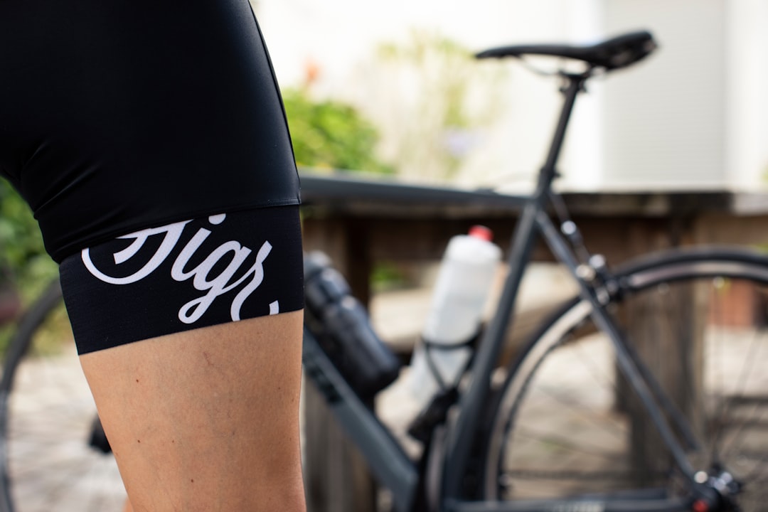 Close-up of a cyclist pedaling on a road bike with a power meter visible.