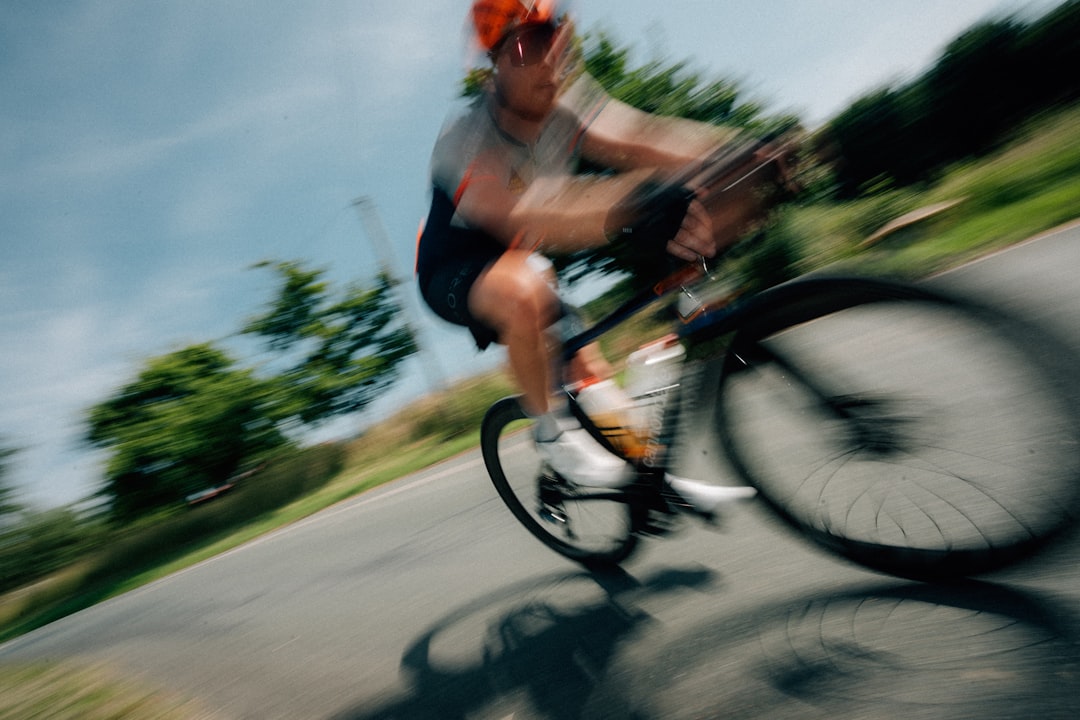 Close-up of a cyclist pedaling on a road bike with a power meter visible.