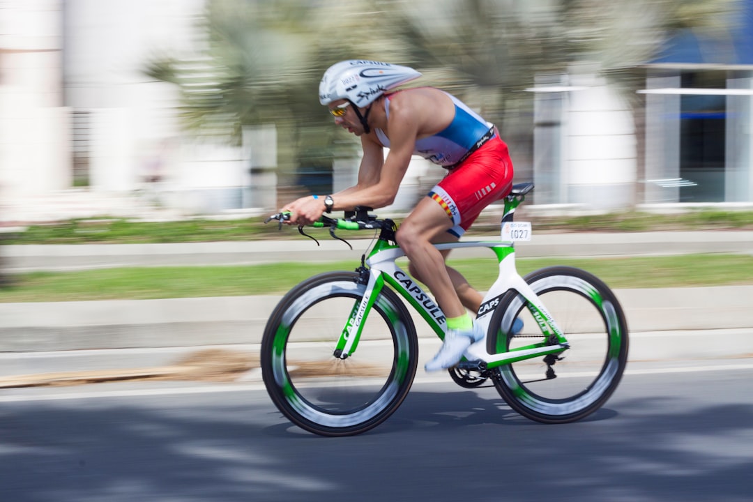 Close-up of a cyclist pedaling on a road bike with a power meter visible.