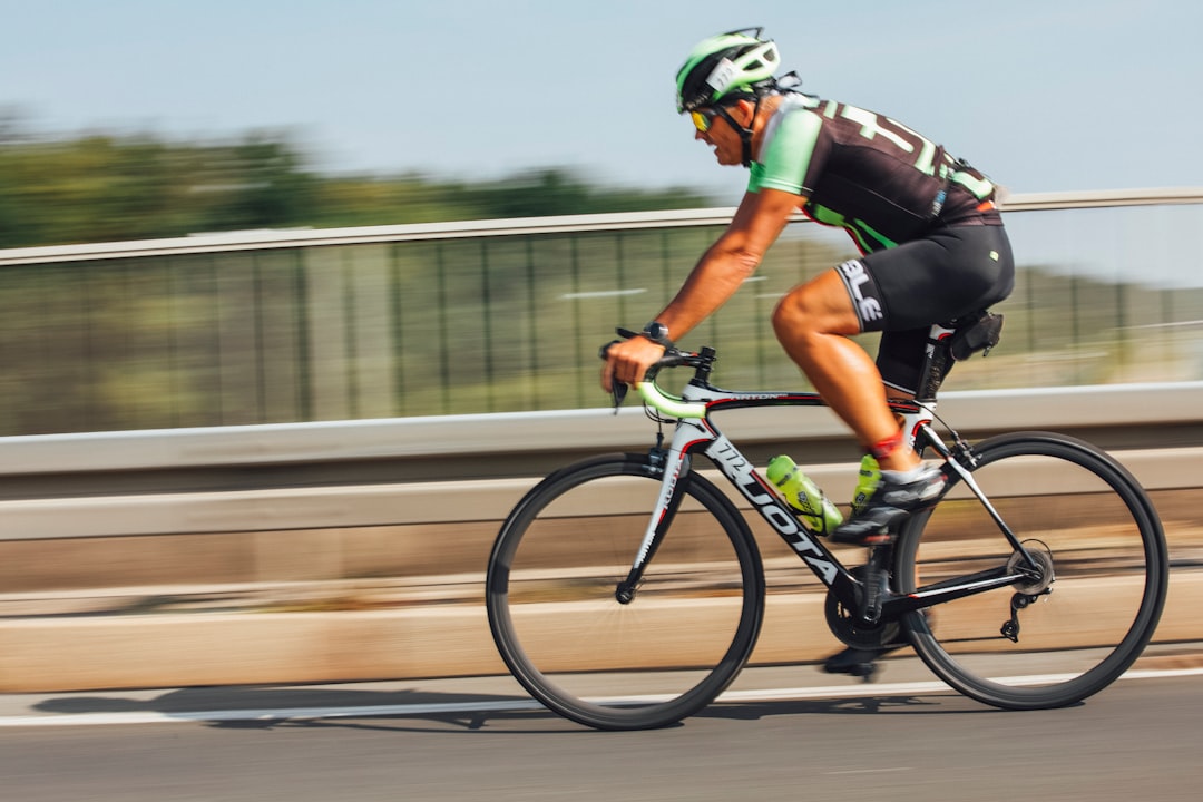 Close-up of a cyclist pedaling on a road bike with a power meter visible.