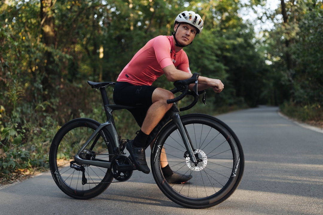 Close-up of a cyclist pedaling on a road bike with a power meter visible.