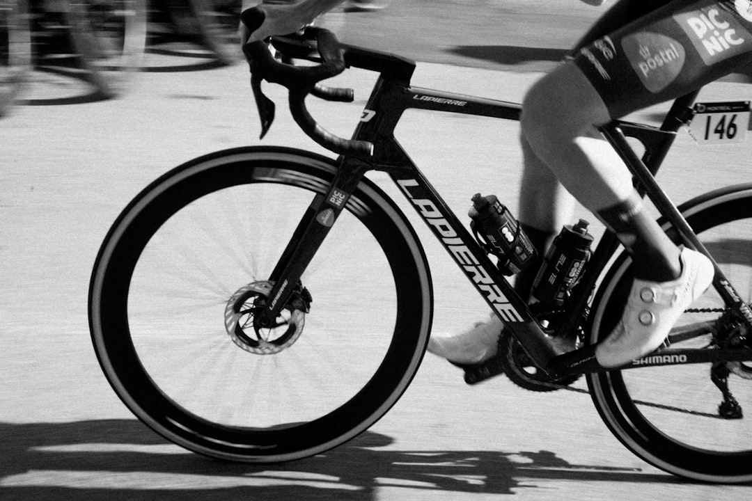 Close-up of a cyclist pedaling on a road bike with a power meter visible.