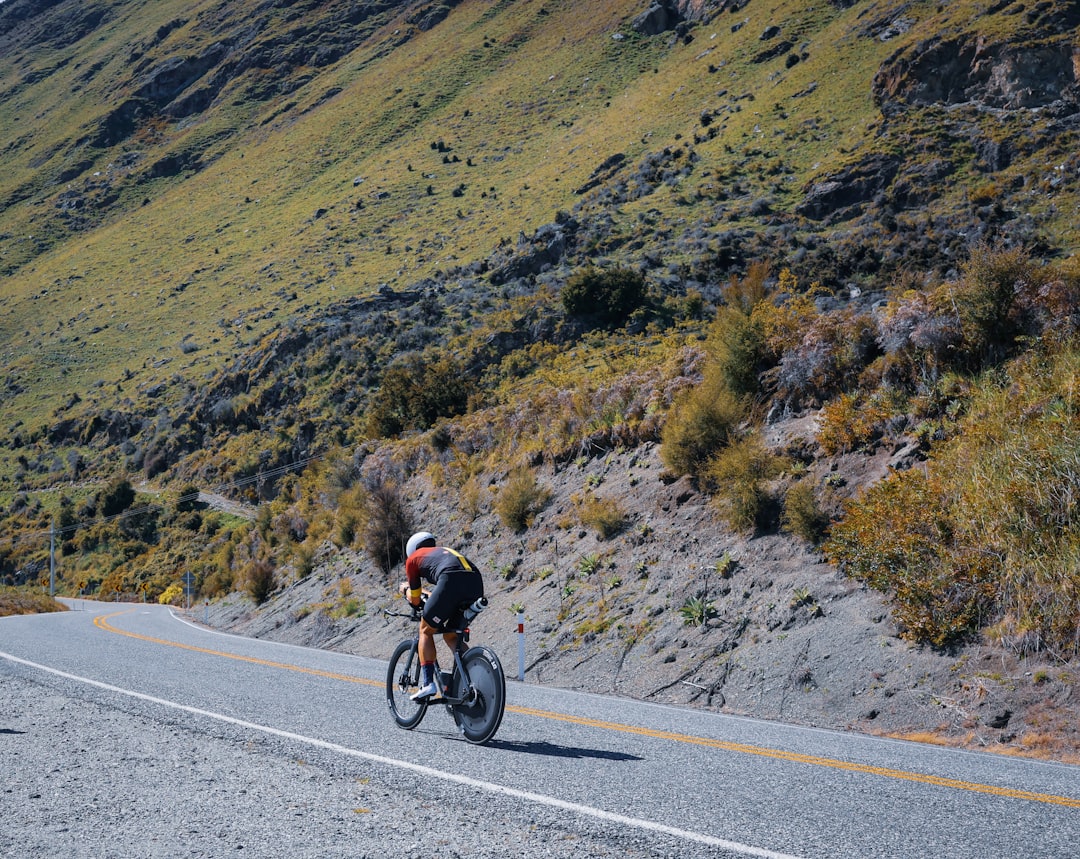 Close-up of a cyclist pedaling on a road bike with a power meter visible.